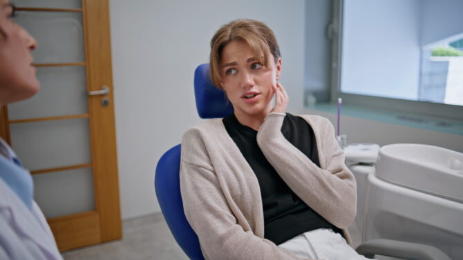 Patient experiencing jaw discomfort during a dental consultation