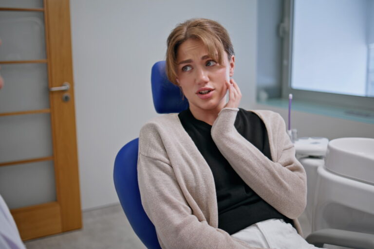 Patient experiencing jaw discomfort during a dental consultation