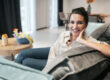 Smiling woman relaxing comfortably on a sofa at home