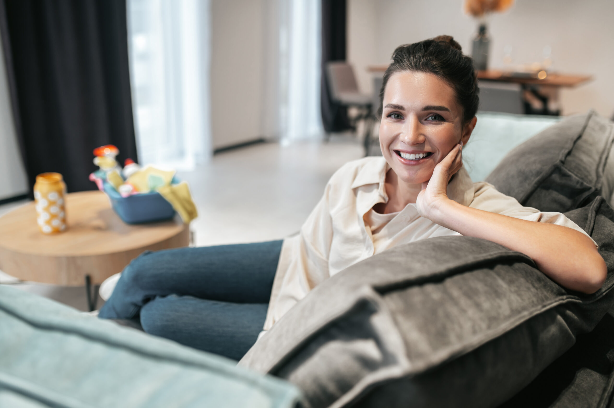 Smiling woman relaxing comfortably on a sofa at home