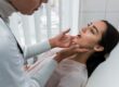 Dentist examining a woman’s jaw during a dental checkup.