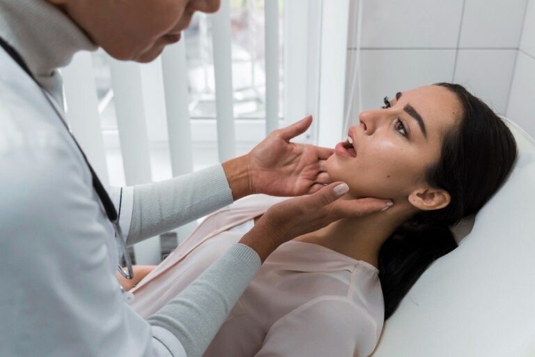 Dentist examining a woman’s jaw during a dental checkup.
