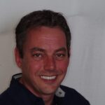 Smiling man with clean white teeth after dental cleaning.