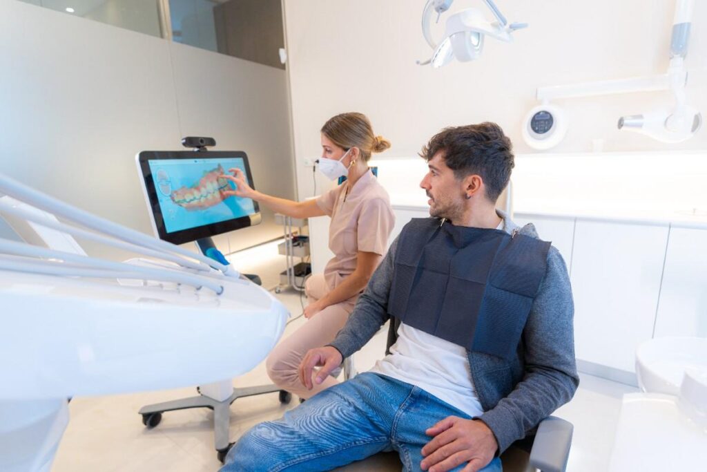 Dentist showing digital smile design to patient in modern clinic