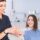 Dentist explaining dental crown treatment with tooth model to patient