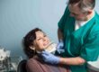 Dentist explaining tooth shade options to a smiling patient.