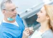 Dentist explaining a dental implant treatment plan to a patient using a dental model