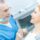 Dentist explaining a dental implant treatment plan to a patient using a dental model