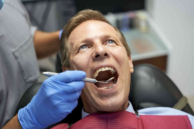 invisalign-treatment-planning Dentist examining a patient's teeth during a dental checkup.